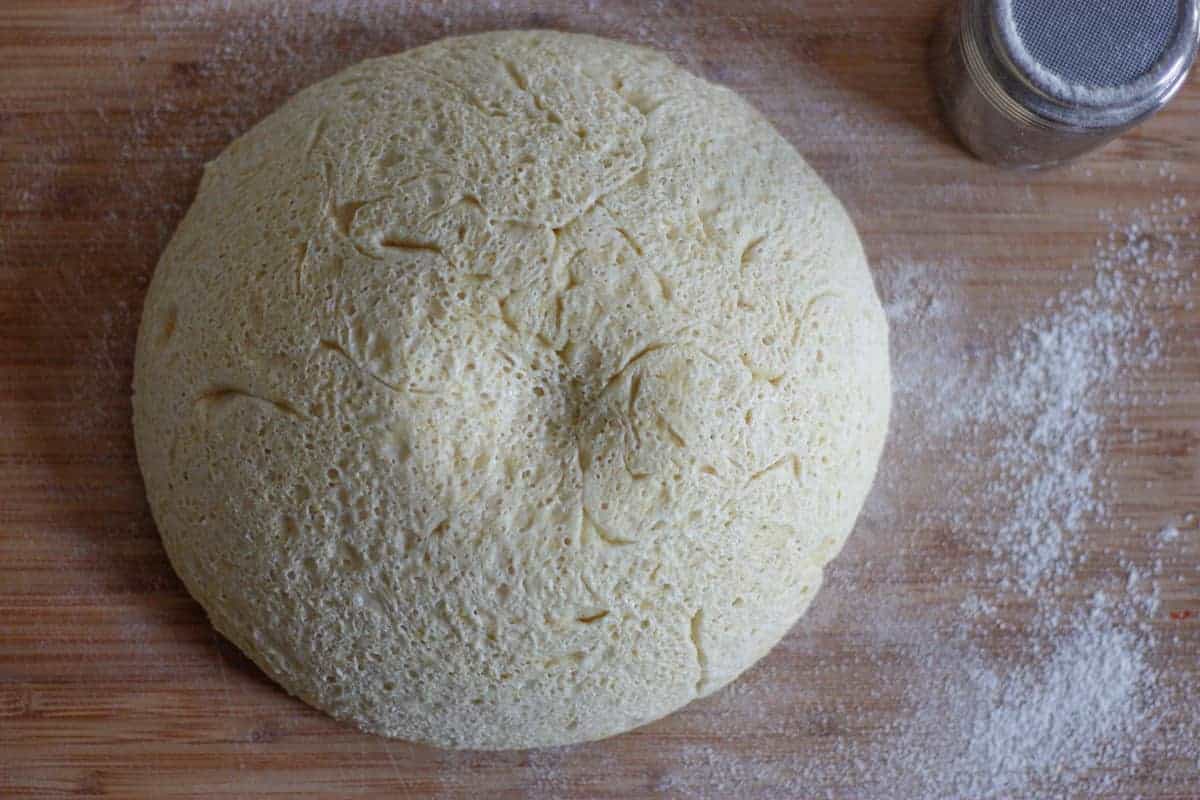 Dome of dough with honeycomb appearance resting on a wooden surface