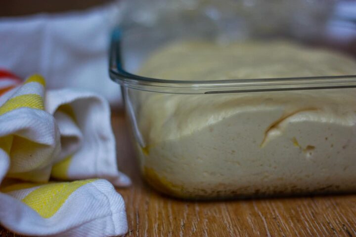 Bubbly dough in a glass dish.