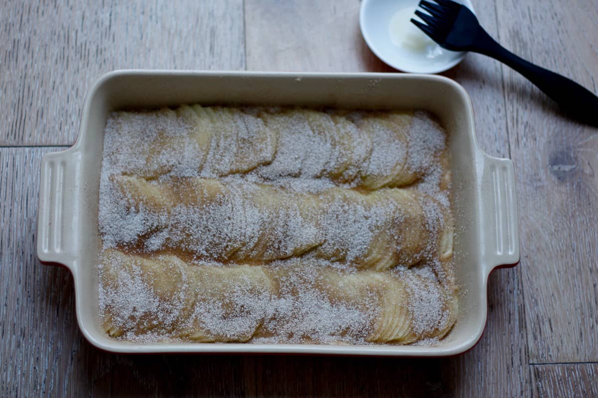 Apple cake ready for the oven. The apples have been sprinkled with cinnamon sugar.